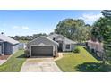 Inviting single-story home with manicured lawn, mature trees, and a two-car garage at 2511 Chatham Cir, Kissimmee, FL 34746