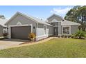 Charming single-story home featuring a well-kept lawn, walkway, and neutral gray exterior at 2511 Chatham Cir, Kissimmee, FL 34746