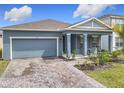 Single-Gathering home with a brick driveway, attached garage, and a welcoming front porch at 338 Crestwind Dr, Daytona Beach, FL 32124