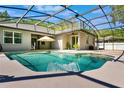 An inviting pool with water feature set into a screened enclosure with backyard views at 3415 Starbird Dr, Ocoee, FL 34761