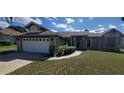 Well-maintained single-story home featuring a two car garage, manicured lawn, and covered entryway at 4421 Steed Ter, Winter Park, FL 32792