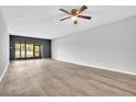 Spacious living room featuring wood-look floors, a ceiling fan, and bright natural light at 5122 Cypress Creek Dr # 103, Orlando, FL 32811