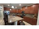 Spacious kitchen featuring stainless steel appliances, granite countertops, and wood cabinets at 5520 Solterra Cir, Davenport, FL 33837