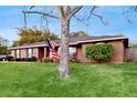 View of the brick home with a neatly kept lawn and American flag at 650 N 4Th Ave, Deltona, FL 32725