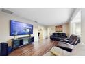 Spacious living room featuring hardwood floors and a large screen television at 650 N 4Th Ave, Deltona, FL 32725