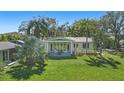 Spacious backyard featuring a covered patio and lush landscaping with palm trees at 703 Valencia Shores Dr, Winter Garden, FL 34787