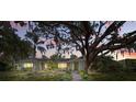 Charming single-story home featuring a lush front yard, mature oak tree, and inviting walkway at 703 Valencia Shores Dr, Winter Garden, FL 34787
