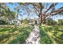 Charming home with a meticulously manicured lawn, complemented by a beautiful walkway and mature trees at 703 Valencia Shores Dr, Winter Garden, FL 34787