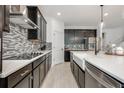 Stylish kitchen featuring dark cabinetry, stainless steel appliances, and a farmhouse sink at 737 Hyperion Dr, Debary, FL 32713