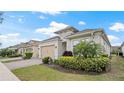 Beautiful home exterior featuring a beige garage door, paver driveway, and lush landscaping at 7928 Hanson Bay Pl, Kissimmee, FL 34747