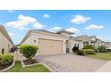 A beautiful home with a beige garage door, paver driveway, and lush landscaping at 7928 Hanson Bay Pl, Kissimmee, FL 34747