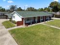 A charming single-story home featuring a brick facade, white columns, and a well-manicured lawn, and solar panels at 812 Arlington Blvd, Altamonte Springs, FL 32701