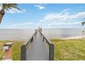 Picturesque view of a long wooden dock extending into a calm lake under a partly cloudy blue sky at 106 Waterwood Dr, Yalaha, FL 34797