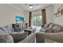 A living room that leads to a balcony with a ceiling fan, television and comfortable furniture at 1301 Tuscan Ter # 9405, Davenport, FL 33896