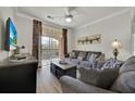 Inviting living room with balcony access, perfect for relaxing or entertaining guests with television and ceiling fan at 1301 Tuscan Ter # 9405, Davenport, FL 33896