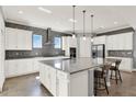 Spacious kitchen features white cabinets, granite countertops, stainless appliances, and a large center island with seating at 13628 Abberwick Dr, Orlando, FL 32832