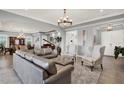 Bright living room with open floor plan, a leather sofa, wingback chairs, and stylish lighting fixtures at 13628 Abberwick Dr, Orlando, FL 32832