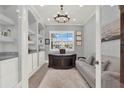 Well-lit home office featuring custom built-ins, large desk, comfortable couch, and neutral color palette at 13628 Abberwick Dr, Orlando, FL 32832