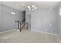 Open-concept room with high ceiling, tile floors, and decorative staircase at 14399 Wabasso Loop, Winter Garden, FL 34787