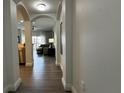 Hallway with an arched opening into the living area and wood flooring at 14501 Grove Resort Ave # 3601, Winter Garden, FL 34787