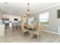 Spacious dining area adjacent to the kitchen, featuring stylish lighting and wood-look tile floors at 15216 Langsdale Ct, Mascotte, FL 34753