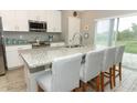 Bright kitchen with granite counters, stainless appliances, and a breakfast bar with seating at 15216 Langsdale Ct, Mascotte, FL 34753