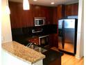 Kitchen featuring stainless steel appliances, wooden cabinets and a breakfast bar at 155 S Court Ave # 1613, Orlando, FL 32801
