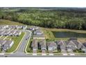 Aerial view of the neighborhood with a large pond and lush greenery at 17398 Saw Palmetto Ave, Clermont, FL 34714