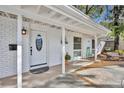 Inviting front porch with a decorative door, potted plants, and cozy seating area at 1821 Mohican Trl, Maitland, FL 32751