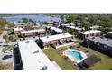 Aerial view of a townhome complex with a community pool, tennis courts and lake in the background at 1836 N Crystal Lake Dr # 104, Lakeland, FL 33801