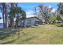 Cozy lake house with mature trees and a grassy front yard at 18951 Lake Pickett Rd, Orlando, FL 32820