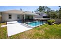 Fenced backyard view with an in-ground pool and covered patio with seating area at 2050 1St Ave, Deland, FL 32724