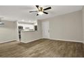 Open-concept living space with sleek wood-look flooring, flowing into the kitchen area at 2548 Oak Park Way # 102, Orlando, FL 32822