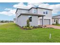 A well-kept lawn highlights this home's two-car garage, neat landscaping, and neutral exterior at 2917 Wild Olive Dr, St Cloud, FL 34772