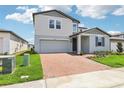 Charming two-story home with a well-manicured lawn and brick paver driveway at 2925 Wild Olive Dr, St Cloud, FL 34772
