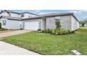 Charming single-Gathering home featuring well-manicured lawn, brick driveway, and modern gray siding at 2929 Wild Olive Dr, St Cloud, FL 34772