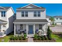 Inviting two-story home with a cozy front porch featuring rocking chairs and manicured landscaping at 5602 Stockade Blvd, St Cloud, FL 34771