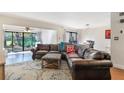 Inviting living room featuring a plush leather sofa, neutral rug, and plenty of natural light from sliding glass doors at 643 Woodridge Dr, Fern Park, FL 32730