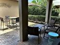 Back patio with brick floor, outdoor furniture and trimmed hedges at 7112 Enchanted Lake Dr, Winter Garden, FL 34787