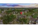 Aerial view of a resort community showing well-manicured grounds, yellow townhomes, and a golf course under a dramatic sky at 7512 Seven Eagles Way # 7512, Reunion, FL 34747