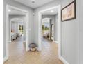 Hallway view showcasing tile flooring and arched doorways leading to bedrooms and a sunlit living area with serene views at 7512 Seven Eagles Way # 7512, Reunion, FL 34747
