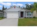 Well-maintained home featuring a freshly painted facade, a red front door, and neat landscaping for a welcoming entrance at 1150 August Sky Dr, Deltona, FL 32738