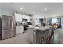 Bright kitchen with stainless steel appliances, granite counters, and an island with bar seating at 1150 August Sky Dr, Deltona, FL 32738