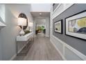 Bright hallway with gray floors, decor, and wall art leading to a living room at 1234 Sand Torch Cir, Davenport, FL 33837
