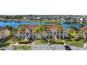 Scenic aerial view of condos by the lake, featuring mature landscaping and ample parking at 13852 Timberbrooke Dr # 203, Orlando, FL 32824