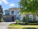 Charming two-story home with lush landscaping and a welcoming brick driveway, set against a clear sky at 14172 Hutchinson St, Winter Garden, FL 34787