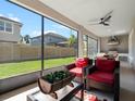 Enjoy outdoor living on this screened-in patio with a ceiling fan, chairs, and outdoor kitchen access at 14172 Hutchinson St, Winter Garden, FL 34787