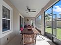 Relaxing screened-in patio with a ceiling fan and comfortable seating, perfect for outdoor dining at 14172 Hutchinson St, Winter Garden, FL 34787