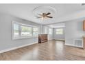 Bright living room featuring hardwood floors, a ceiling fan and natural light from large windows at 1607 India Palm Dr, Edgewater, FL 32132