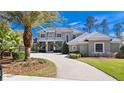 Beautiful two-story home with a circular driveway, mature palm trees, and lush landscaping at 1707 Stetson Ct, Longwood, FL 32779